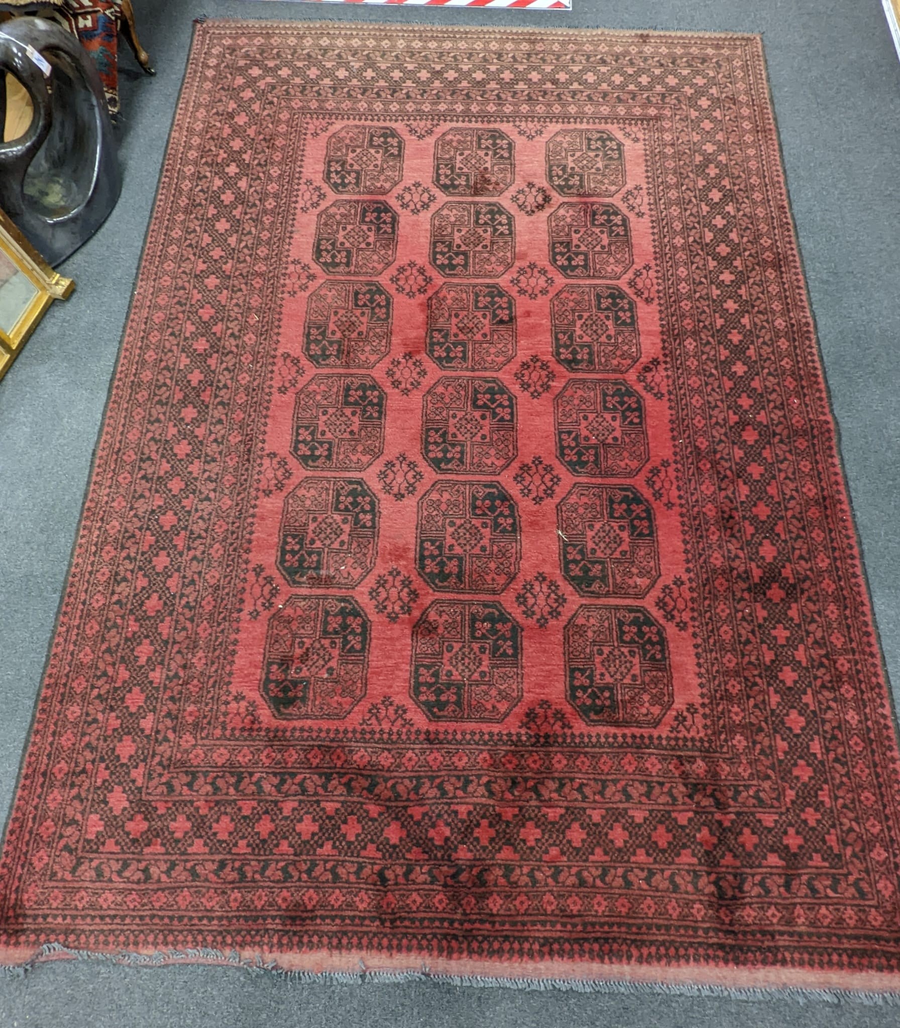 An Afghan red ground carpet, 290 x 200cm